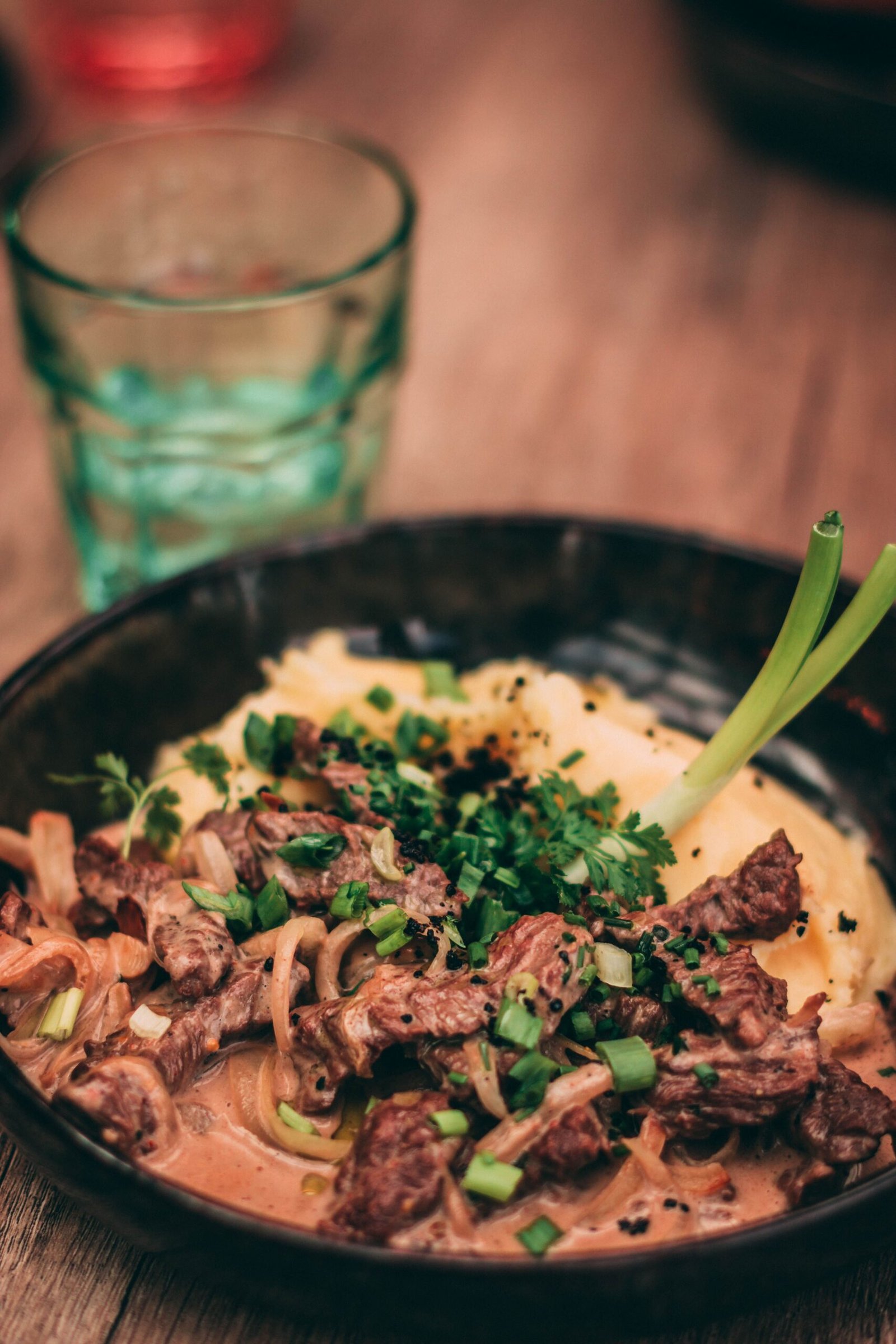 Creamy beef stroganoff garnished with herbs in a bowl