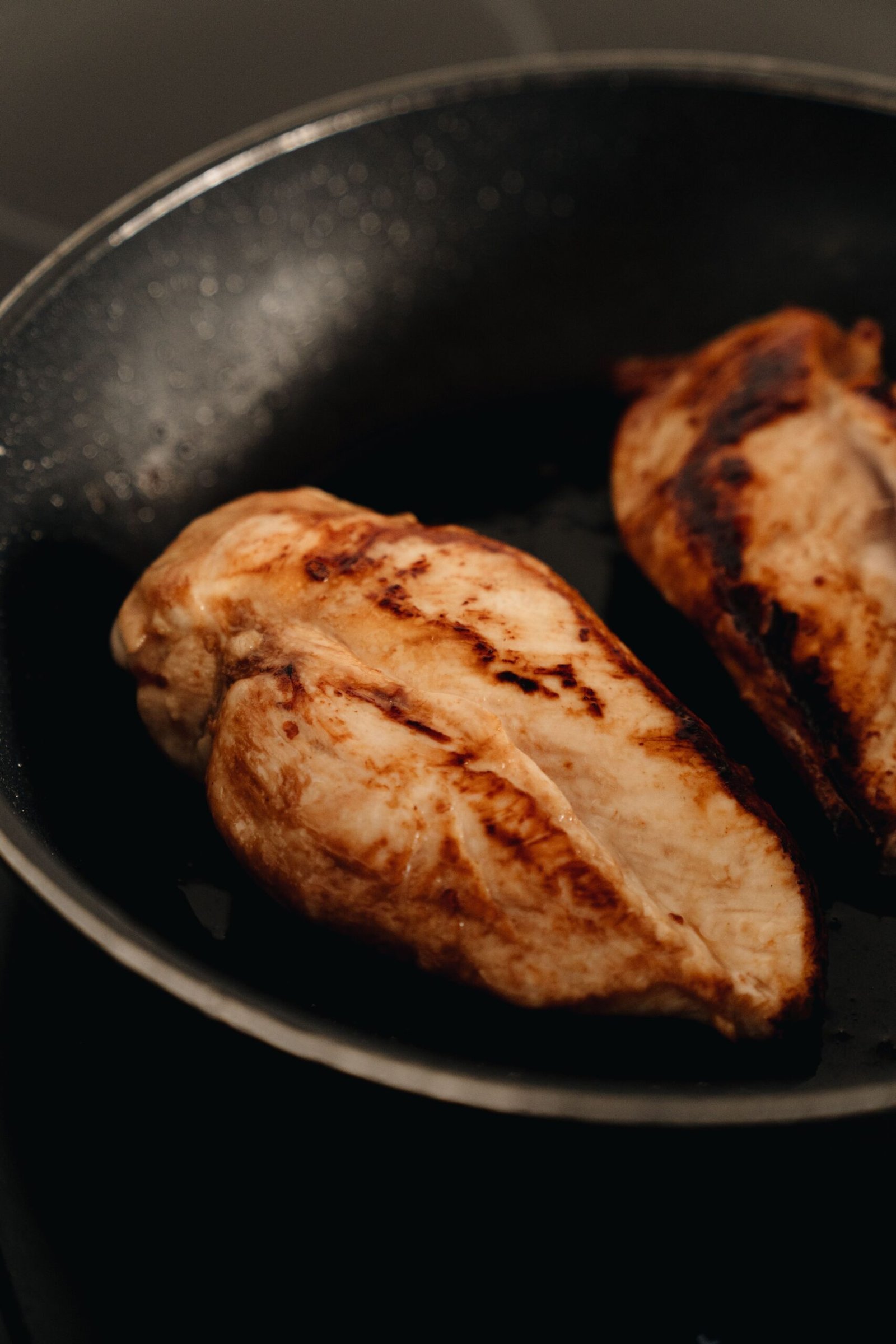 Seared chicken breasts cooking in a skillet