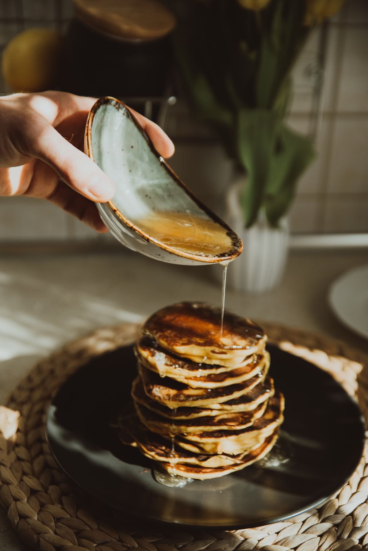 Stack of homemade pancakes with syrup being poured