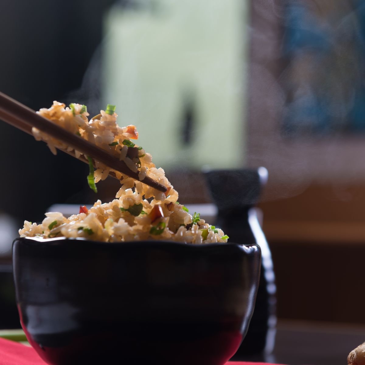 Bowl of fried rice lifted with chopsticks