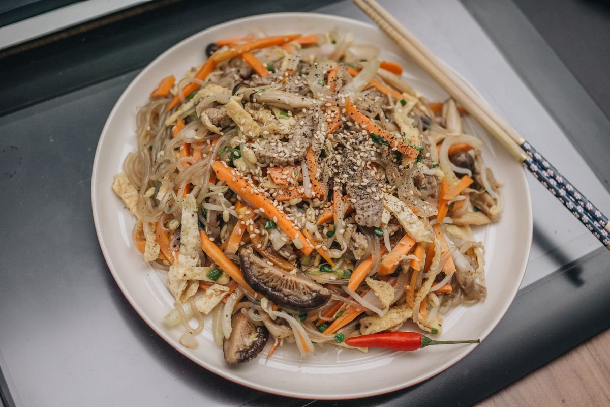 Plate of stir-fried noodles with carrots and mushrooms
