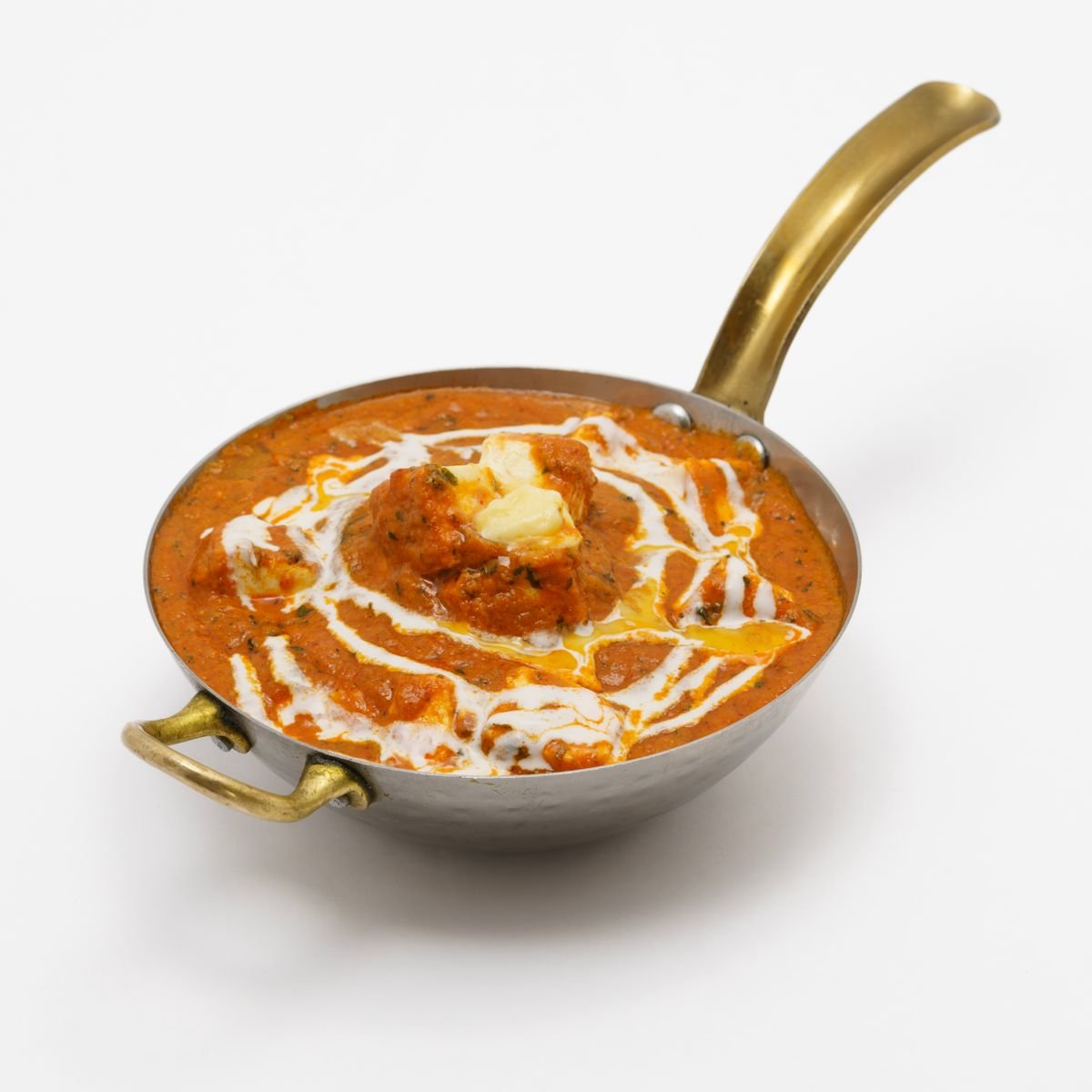 Butter chicken curry with a swirl of cream in a small copper pan