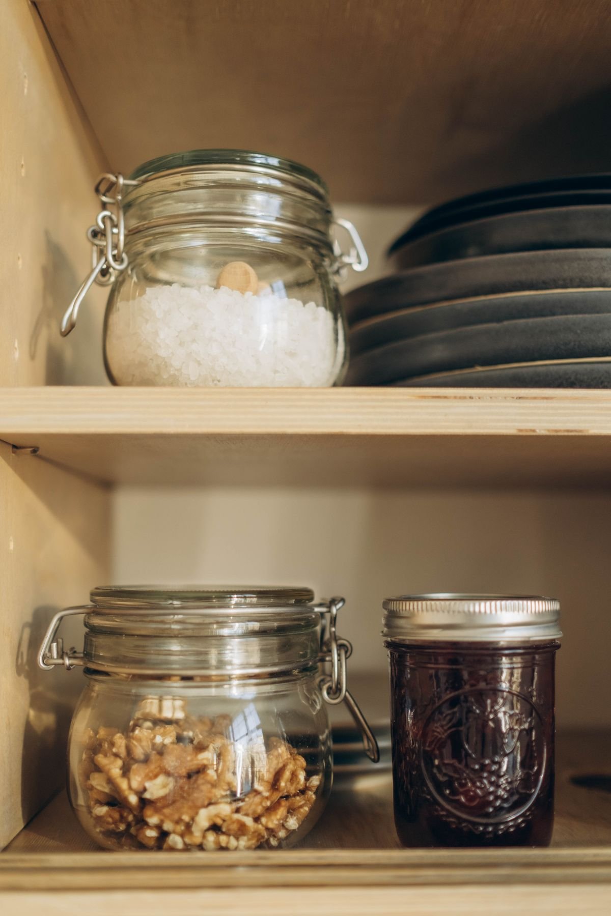 Glass jars of dry goods on a kitchen pantry shelf